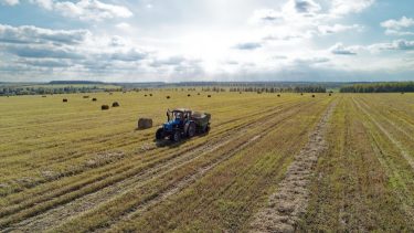 Orosz szántóföld öreg traktor kalászos gabona betakarítása után